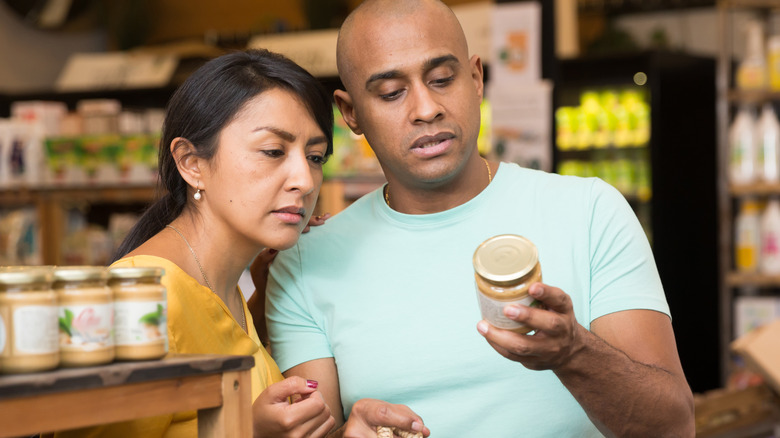 Couple examining ingredients on packaged food