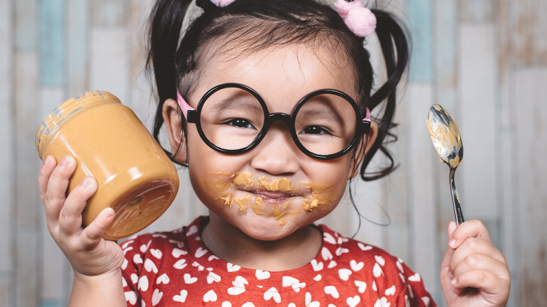 little girl eating peanut butter