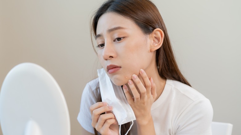 Asian woman looking at blemish