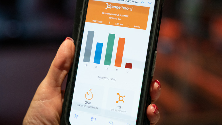 Hand holding phone with Orangetheory stats