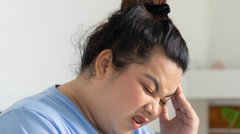 Woman sits with headache