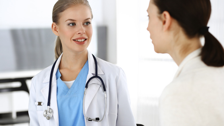patient consulting woman doctor with stethoscope