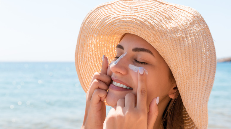 Woman applying sunscreen to her face