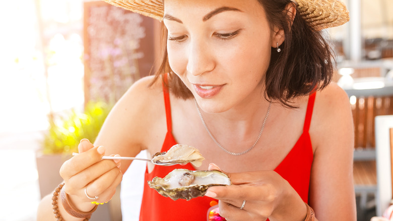 woman eating oyster outdoors