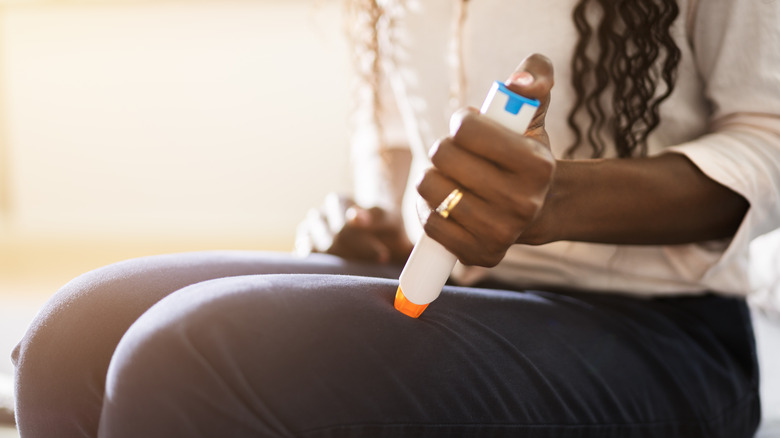 woman using epinephrine with auto-injector