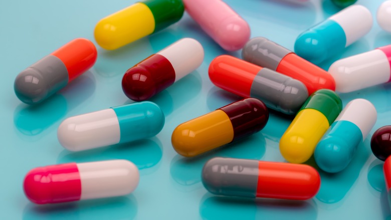 Assorted antibiotic capsules on blue background