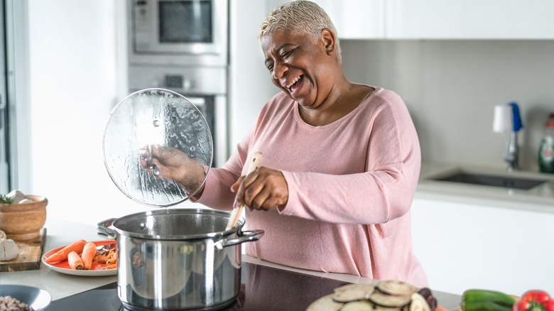 woman smiling and cooking