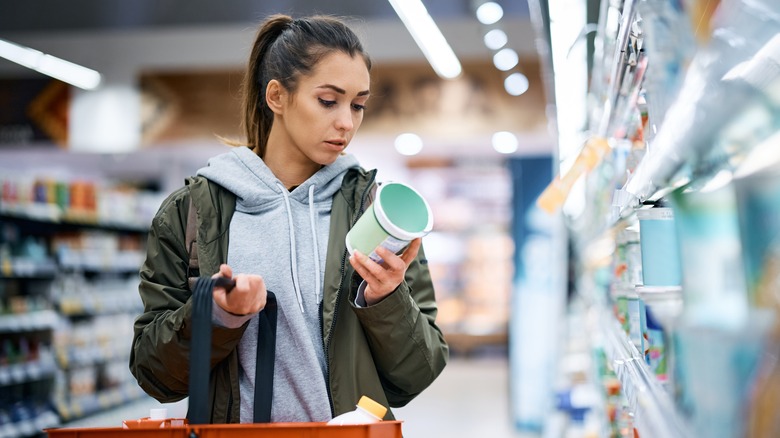 Person in market examines food label