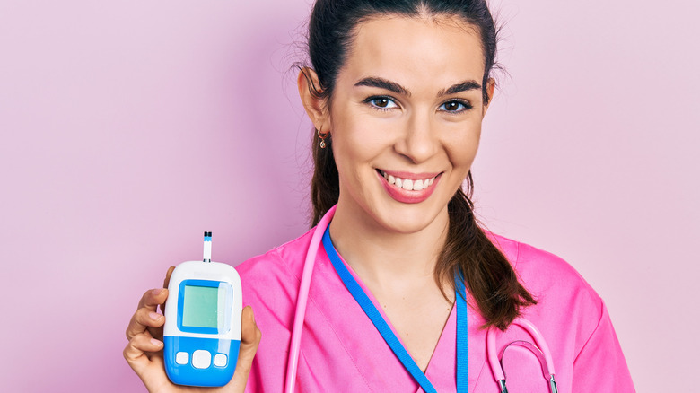 Nurse holding up a blood sugar test