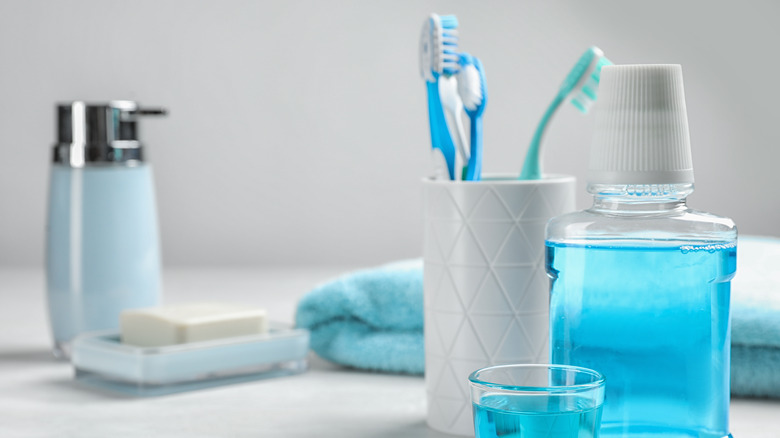 Mouthwash and toothbrushes on bathroom counter