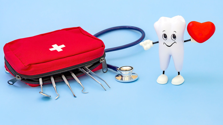 Doctors bag and stethoscope beside tooth figurine