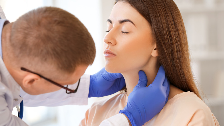 Doctor examining a woman's neck