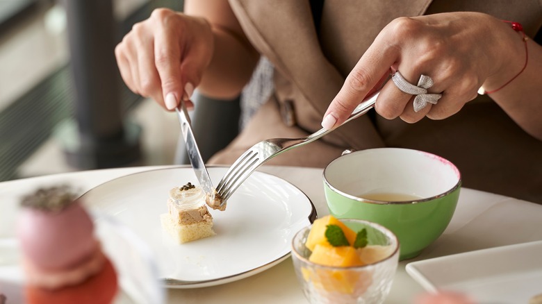 Woman's hands holding knife and fork