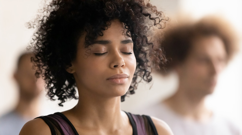 Woman meditating in a group class