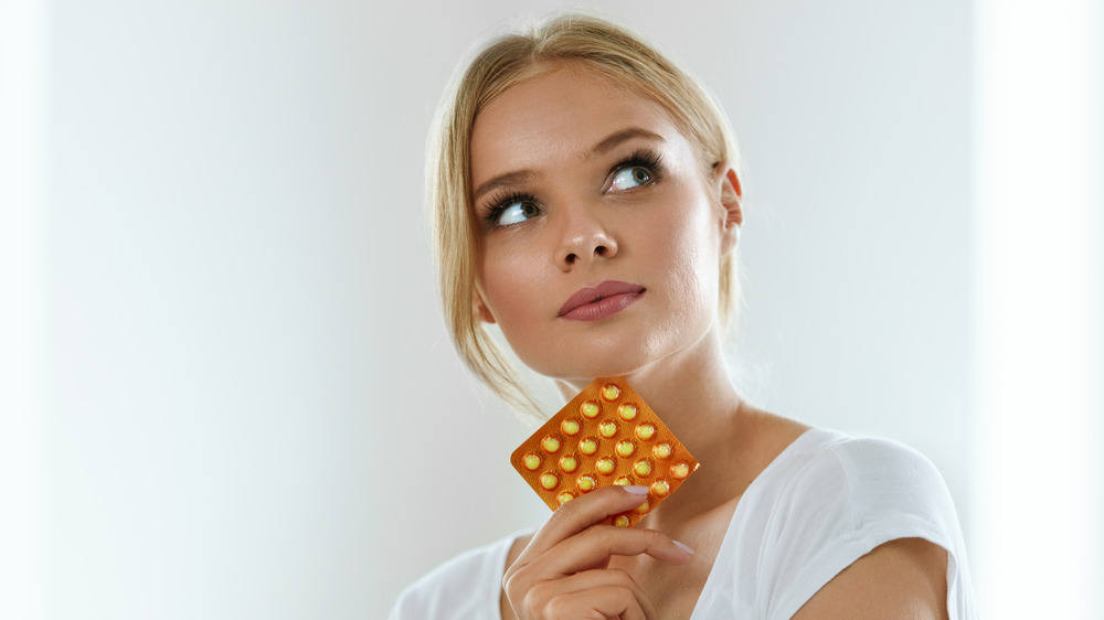 woman holding birth control pills