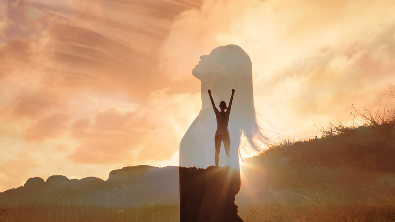 woman looking to the sky and making the sign for victory