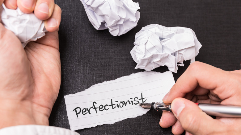 crumpled paper surrounding a page that reads "perfectionist"