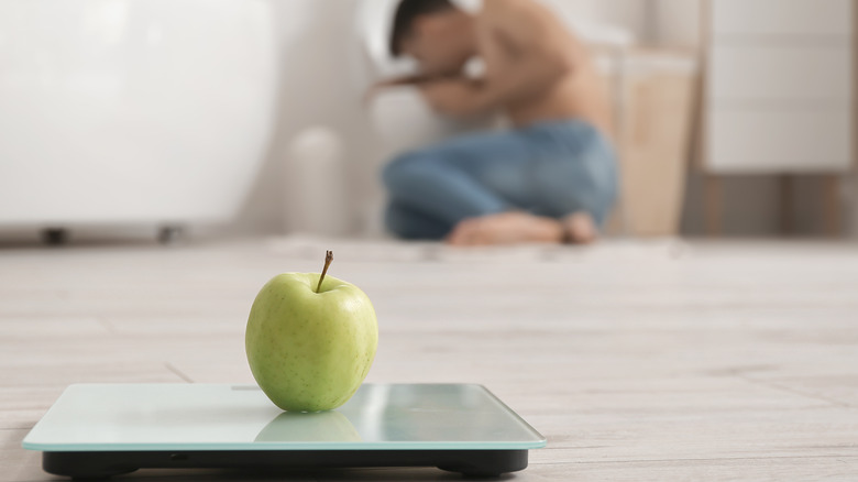 man suffering from bulimia apple foreground