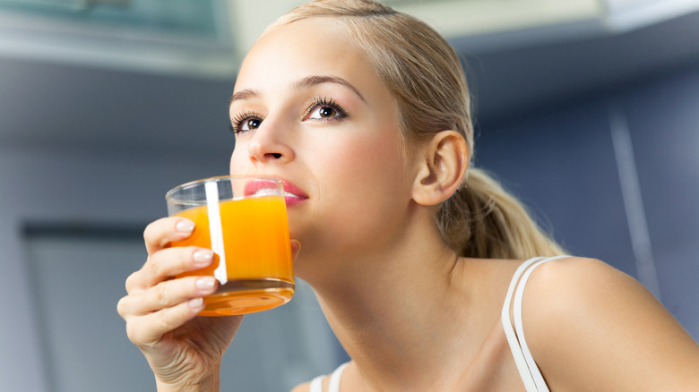 woman drinking orange drink
