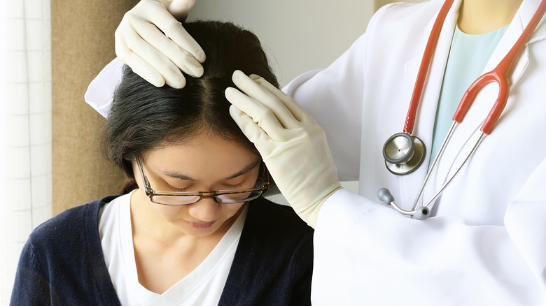 doctor checking patient's hair