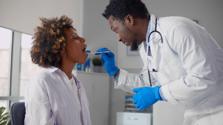 Doctor examining patient's mouth