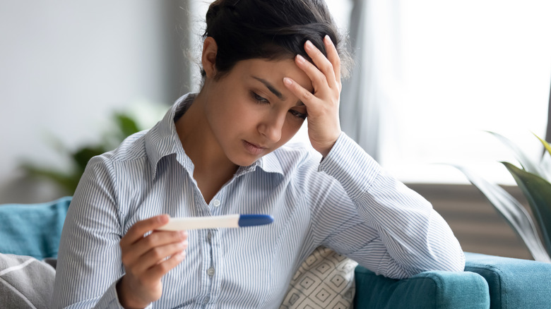woman looking at pregnancy test