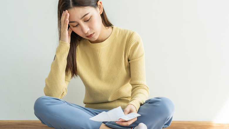 stressed woman looking at bills