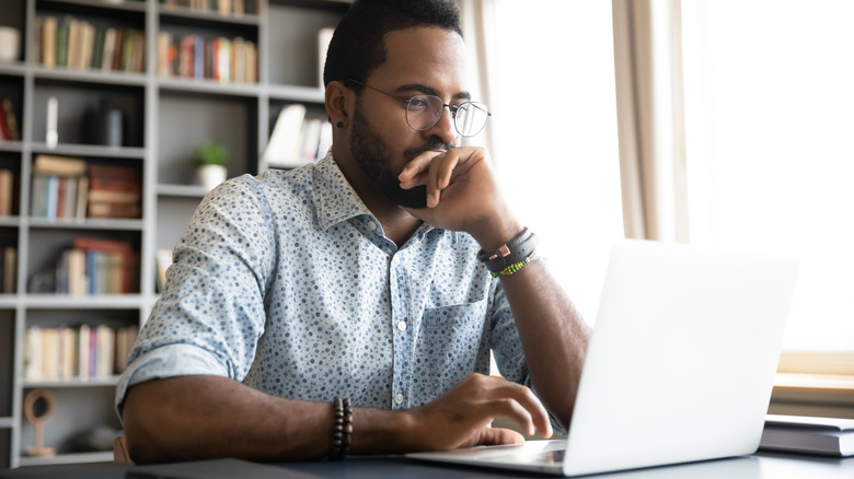 man searching information on laptop