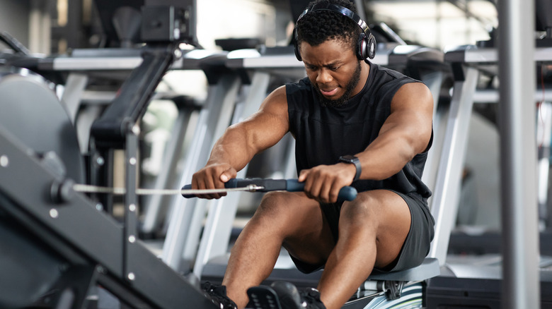 young man on row machine