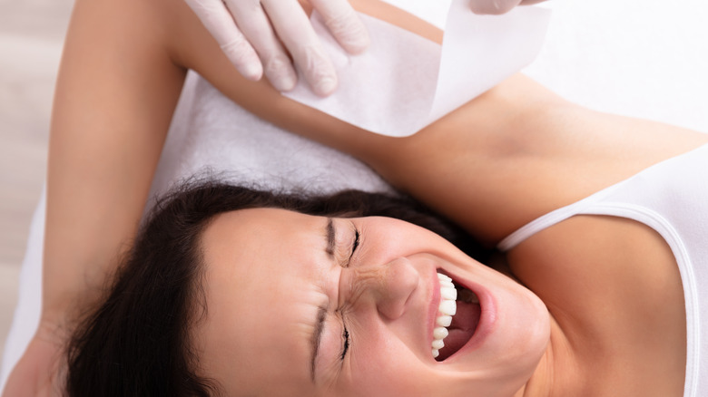woman in pain while getting waxed