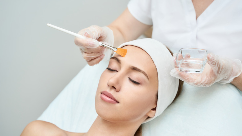 woman with eyes closed getting a chemical peel