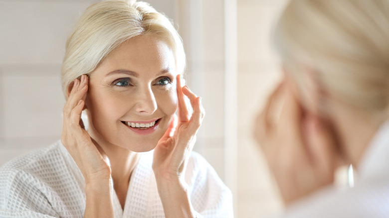 middle-aged woman smiling in mirror