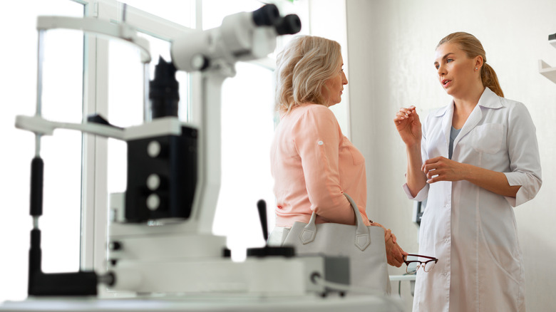 Senior woman talking to eye doctor