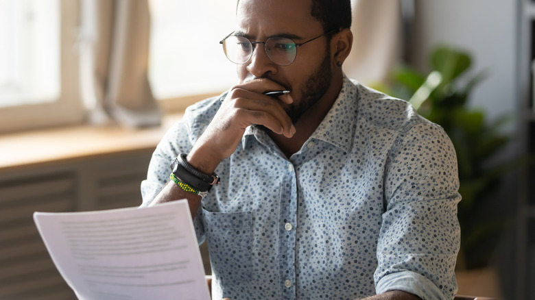 man at table studying paper