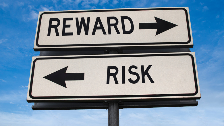 risk-reward street sign with blue sky behind it