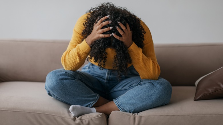 woman holding her head in her hands