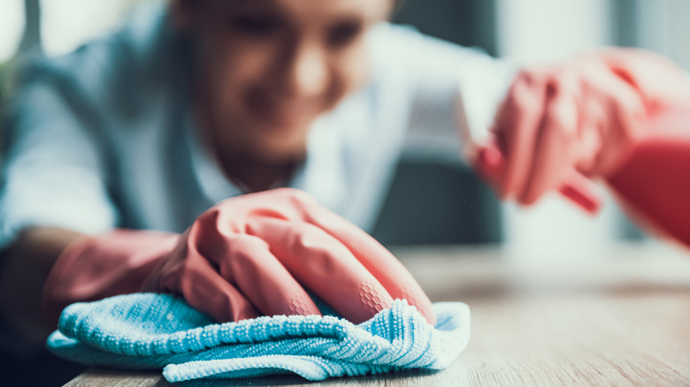 woman cleaning with rag and spray bottle