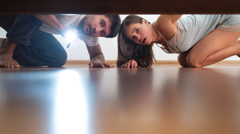couple searching under bed