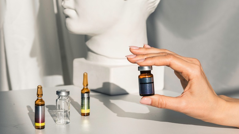 A woman's hand holding a small vial 