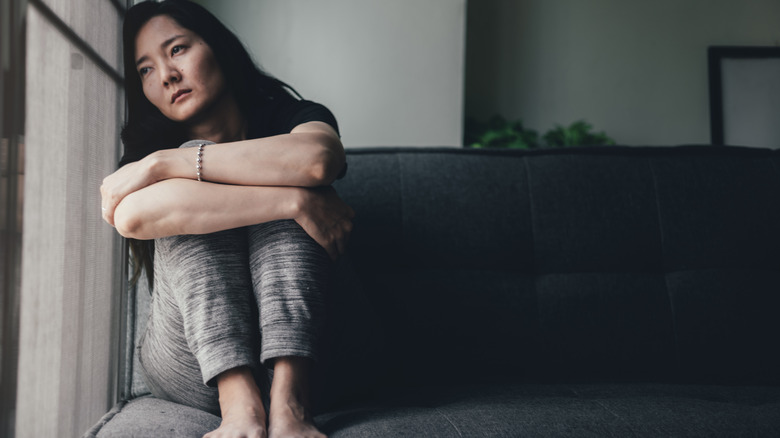 Woman sitting on a couch looking sad and depressed