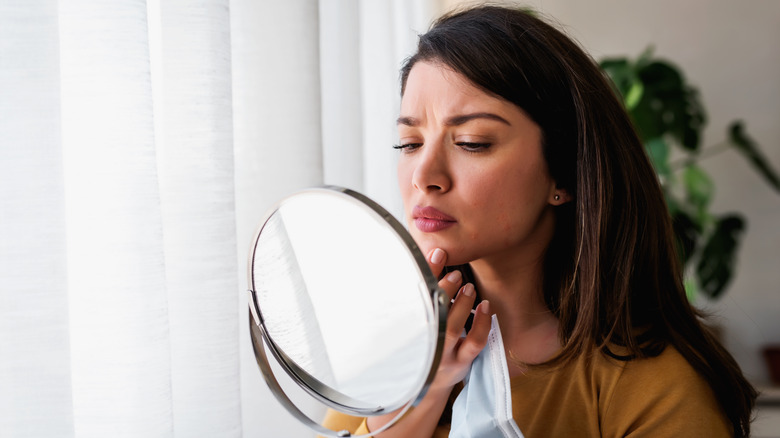 Woman looking in a makeup mirror
