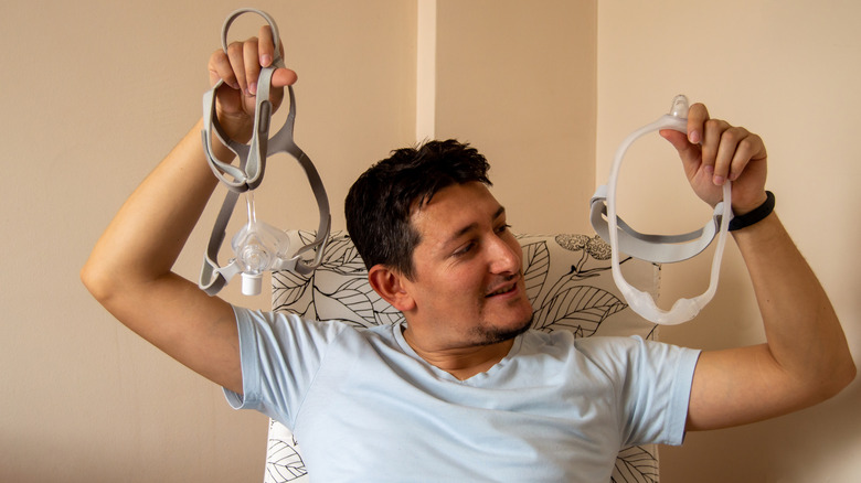 Young man comparing CPAP masks