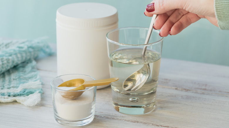 woman mixing collagen powder in glass of water