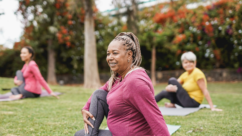 older woman doing yoga in the park