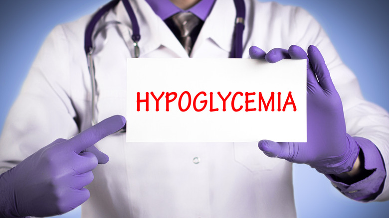 Medical professional holding a card that says "hypoglycemia"