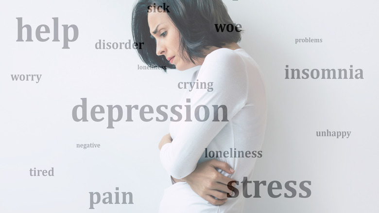 Symptoms of PMDD surrounding woman in pain