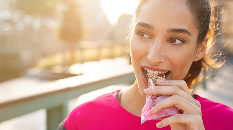 woman eating protein bar