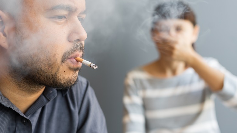 smoking man with irritated woman