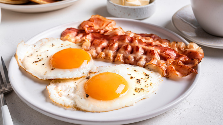 Two fried eggs and bacon on a plate