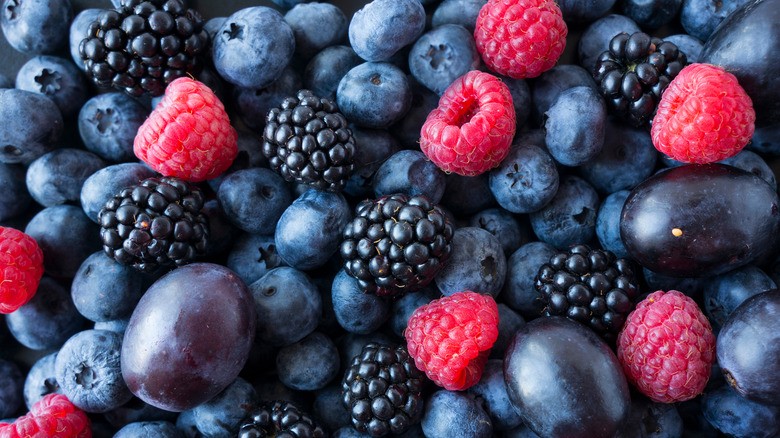 Blueberries, raspberries, blackberries, and grapes piled on top of each other